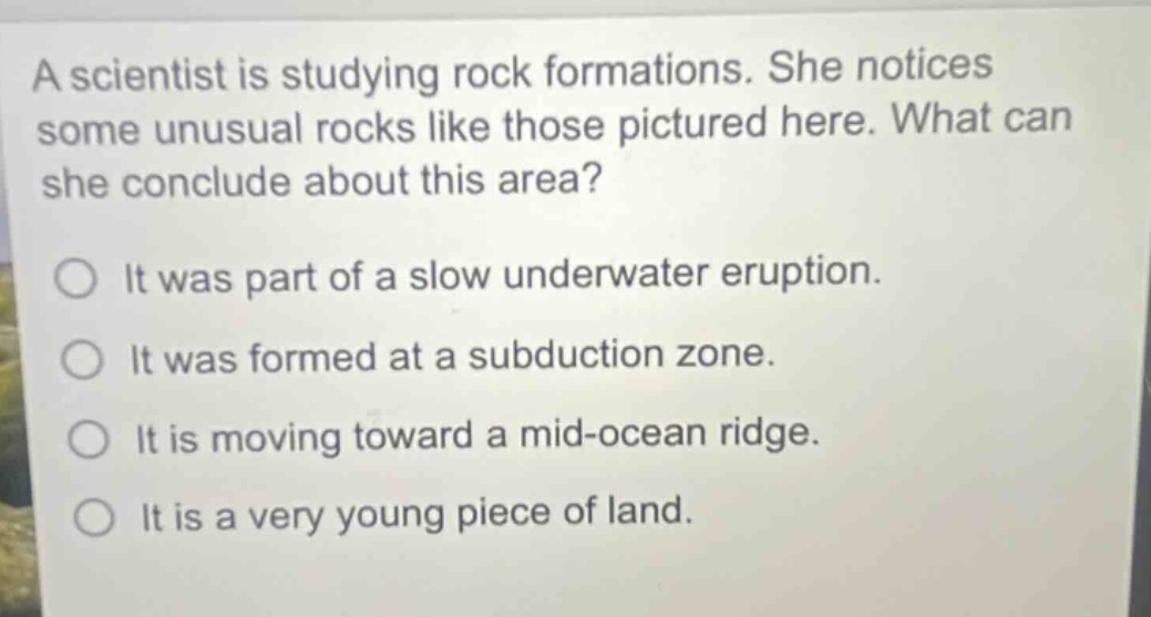 a scientist is studying rock formations. she notices some unusual rocks like those pictured here. what can she conclude about this area? it was part of a slow underwater eruption. it was formed at a subduction zone. it is moving toward a mid - ocean ridge. it is a very young piece of land.