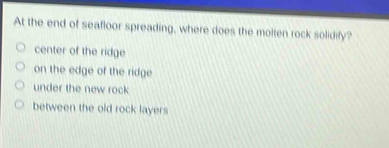 at the end of seafloor spreading, where does the molten rock solidify? center of the ridge on the edge of the ridge under the new rock between the old rock layers