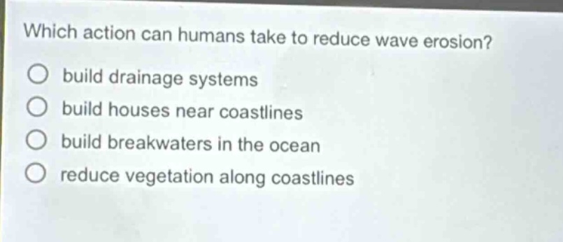 which action can humans take to reduce wave erosion? build drainage systems build houses near coastlines build breakwaters in the ocean reduce vegetation along coastlines