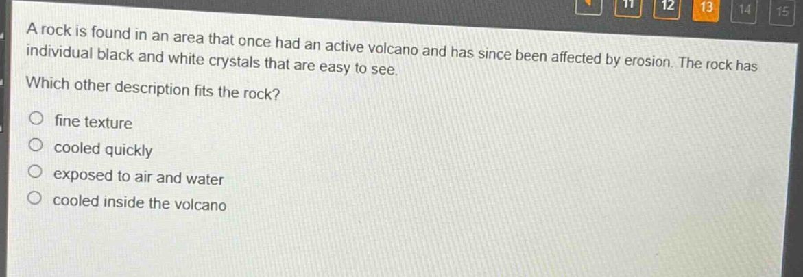 a rock is found in an area that once had an active volcano and has since been affected by erosion. the rock has individual black and white crystals that are easy to see. which other description fits the rock? fine texture cooled quickly exposed to air and water cooled inside the volcano
