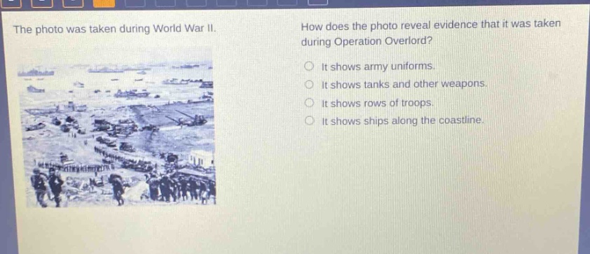 the photo was taken during world war ii. how does the photo reveal evidence that it was taken during operation overlord? it shows army uniforms. it shows tanks and other weapons. it shows rows of troops. it shows ships along the coastline.