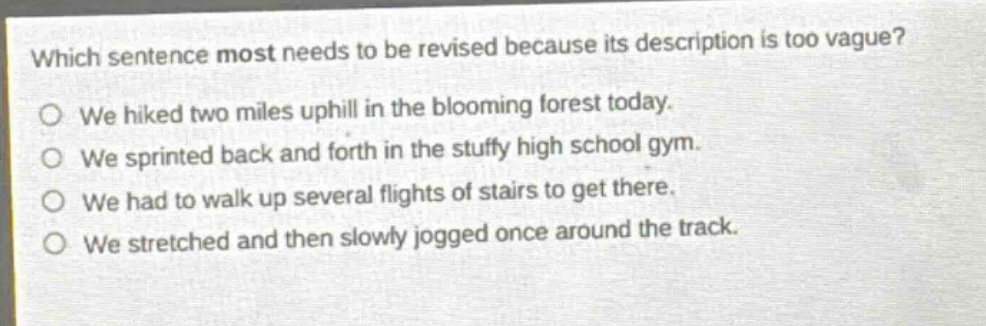 which sentence most needs to be revised because its description is too vague? o we hiked two miles uphill in the blooming forest today. o we sprinted back and forth in the stuffy high school gym. o we had to walk up several flights of stairs to get there. o we stretched and then slowly jogged once around the track.