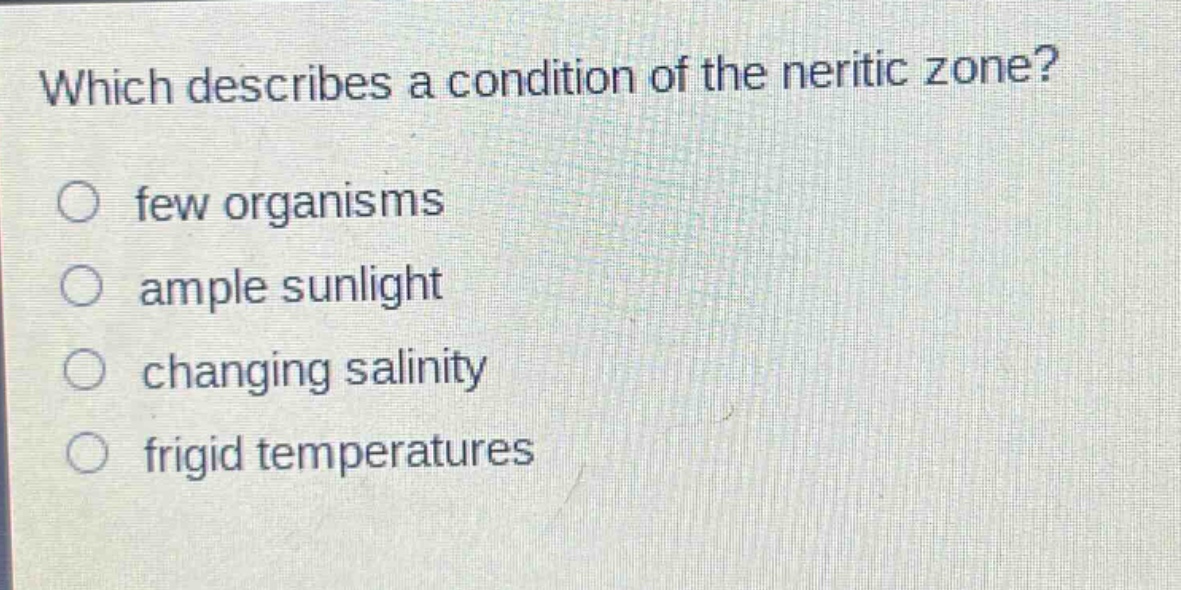 which describes a condition of the neritic zone?\no few organisms\no ample sunlight\no changing salinity\no frigid temperatures