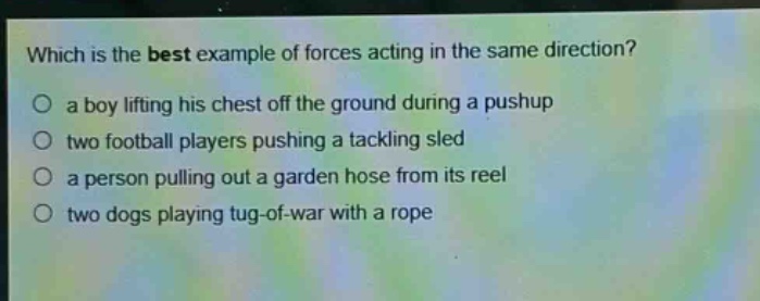 which is the best example of forces acting in the same direction?\no a boy lifting his chest off the ground during a pushup\no two football players pushing a tackling sled\no a person pulling out a garden hose from its reel\no two dogs playing tug - of - war with a rope