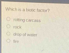 which is a biotic factor?\nrotting carcass\nrock\ndrop of water\nfire