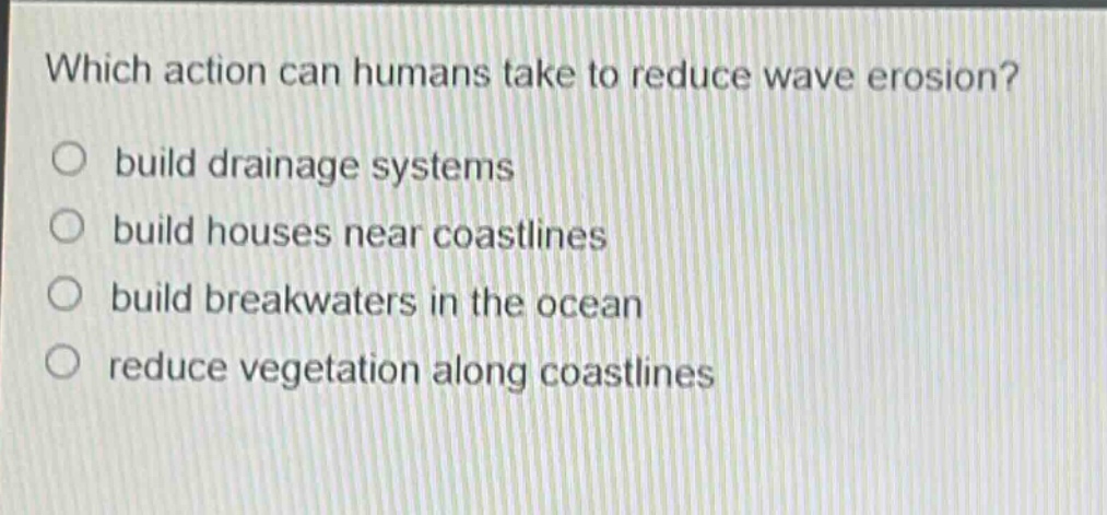 which action can humans take to reduce wave erosion?\nbuild drainage systems\nbuild houses near coastlines\nbuild breakwaters in the ocean\nreduce vegetation along coastlines