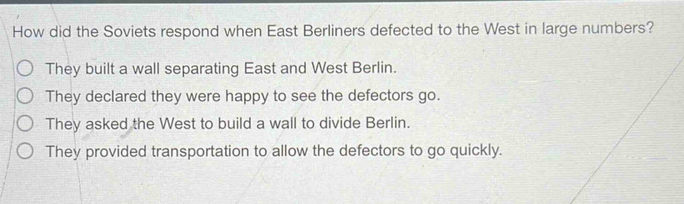 how did the soviets respond when east berliners defected to the west in large numbers?\nthey built a wall separating east and west berlin.\nthey declared they were happy to see the defectors go.\nthey asked the west to build a wall to divide berlin.\nthey provided transportation to allow the defectors to go quickly.