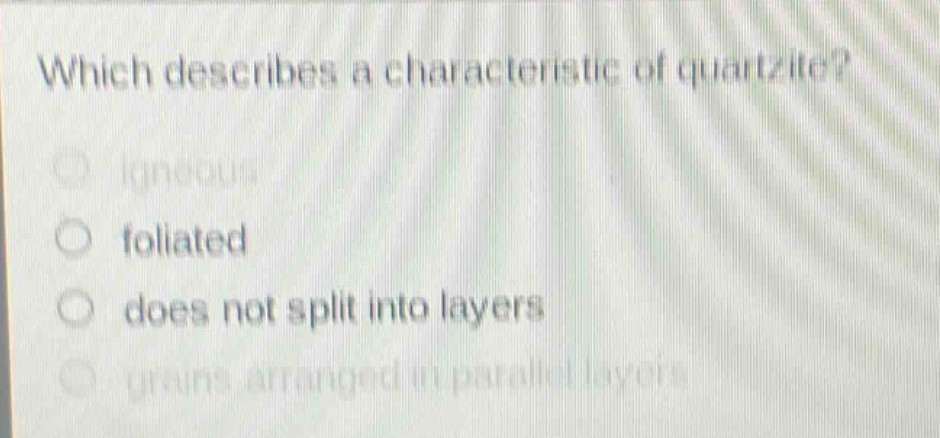 which describes a characteristic of quartzite?\nigneous\nfoliated\ndoes not split into layers\ngrains arranged in parallel layers