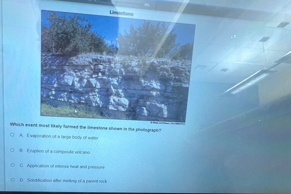 which event most likely formed the limestone shown in the photograph?\na. evaporation of a large body of water\nb. eruption of a composite volcano\nc. application of intense heat and pressure\nd. solidification after melting of a parent rock
