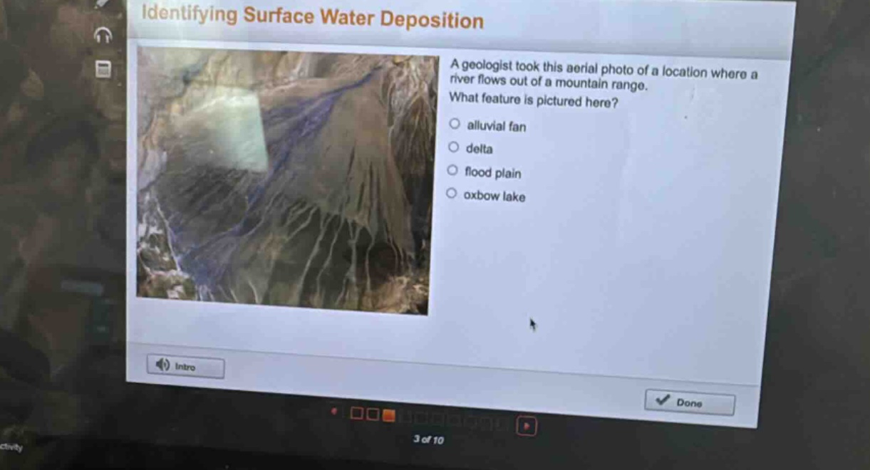identifying surface water deposition\na geologist took this aerial photo of a location where a river flows out of a mountain range.\nwhat feature is pictured here?\nalluvial fan\ndelta\nflood plain\noxbow lake