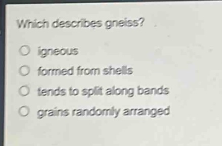 which describes gneiss?\no igneous\no formed from shells\no tends to split along bands\no grains randomly arranged