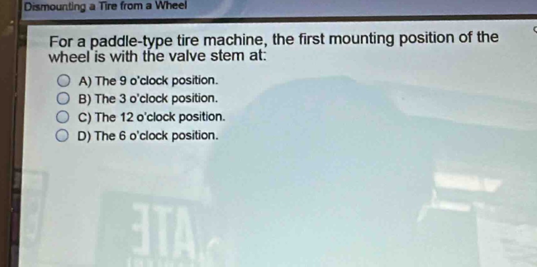 for a paddle - type tire machine, the first mounting position of the wheel is with the valve stem at:\na) the 9 oclock position.\nb) the 3 oclock position.\nc) the 12 oclock position.\nd) the 6 oclock position.