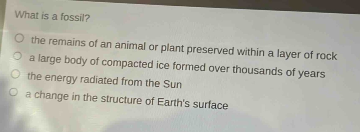 what is a fossil?\no the remains of an animal or plant preserved within a layer of rock\na large body of compacted ice formed over thousands of years\nthe energy radiated from the sun\na change in the structure of earths surface