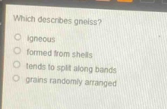 which describes gneiss?\nigneous\nformed from shells\ntends to split along bands\ngrains randomly arranged