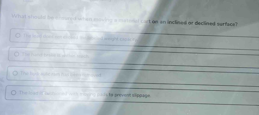 what should be ensured when moving a material cart on an inclined or declined surface?\nthe load does not exceed the labeled weight capacity.\nthe hand brake is within reach.\nthe hydraulic ram has been removed.\nthe load is cushioned with moving pads to prevent slippage.