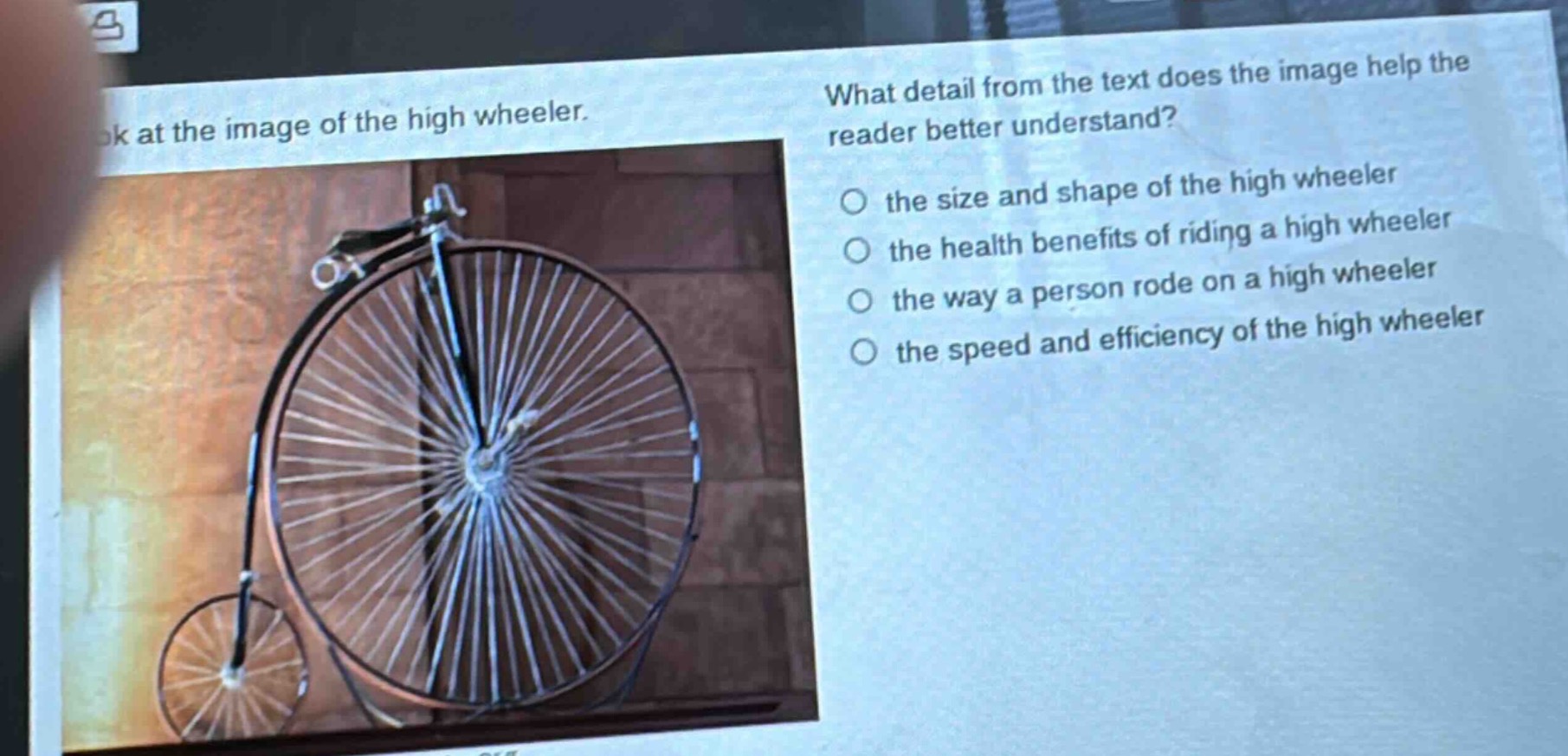 look at the image of the high wheeler. what detail from the text does the image help the reader better understand? the size and shape of the high wheeler the health benefits of riding a high wheeler the way a person rode on a high wheeler the speed and efficiency of the high wheeler