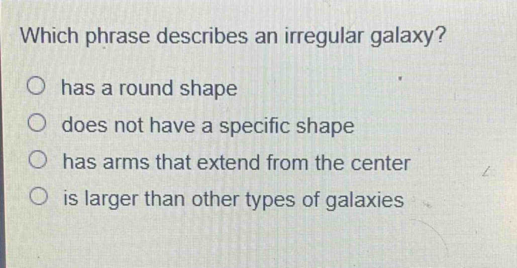 which phrase describes an irregular galaxy?\nhas a round shape\ndoes not have a specific shape\nhas arms that extend from the center\nis larger than other types of galaxies