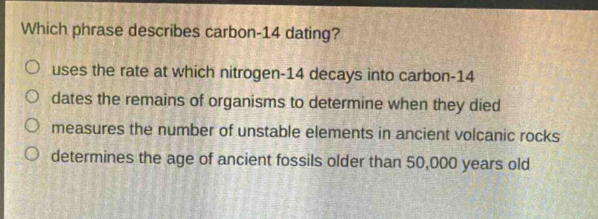 which phrase describes carbon - 14 dating?\no uses the rate at which nitrogen - 14 decays into carbon - 14\no dates the remains of organisms to determine when they died\no measures the number of unstable elements in ancient volcanic rocks\no determines the age of ancient fossils older than 50,000 years old