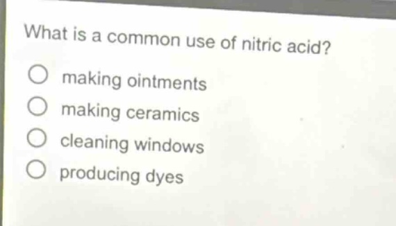 what is a common use of nitric acid?\nmaking ointments\nmaking ceramics\ncleaning windows\nproducing dyes