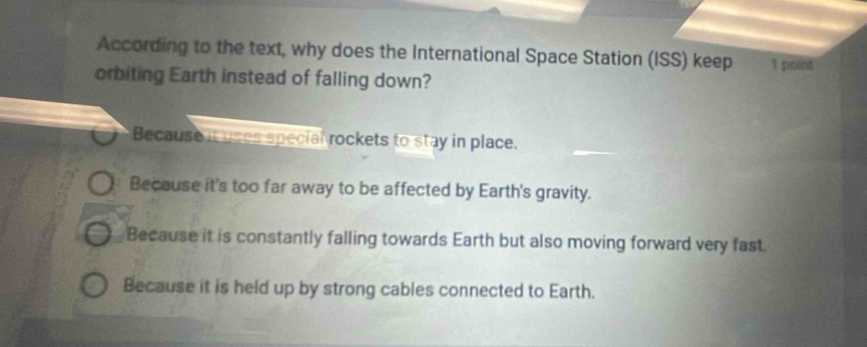according to the text, why does the international space station (iss) keep orbiting earth instead of falling down?\nbecause it uses special rockets to stay in place.\nbecause its too far away to be affected by earths gravity.\nbecause it is constantly falling towards earth but also moving forward very fast.\nbecause it is held up by strong cables connected to earth.
