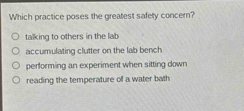 which practice poses the greatest safety concern?\n talking to others in the lab\n accumulating clutter on the lab bench\n performing an experiment when sitting down\n reading the temperature of a water bath