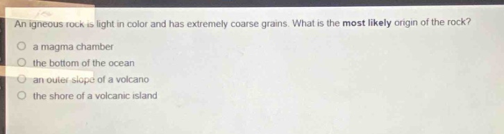 an igneous rock is light in color and has extremely coarse grains. what is the most likely origin of the rock?\no a magma chamber\no the bottom of the ocean\no an outer slope of a volcano\no the shore of a volcanic island