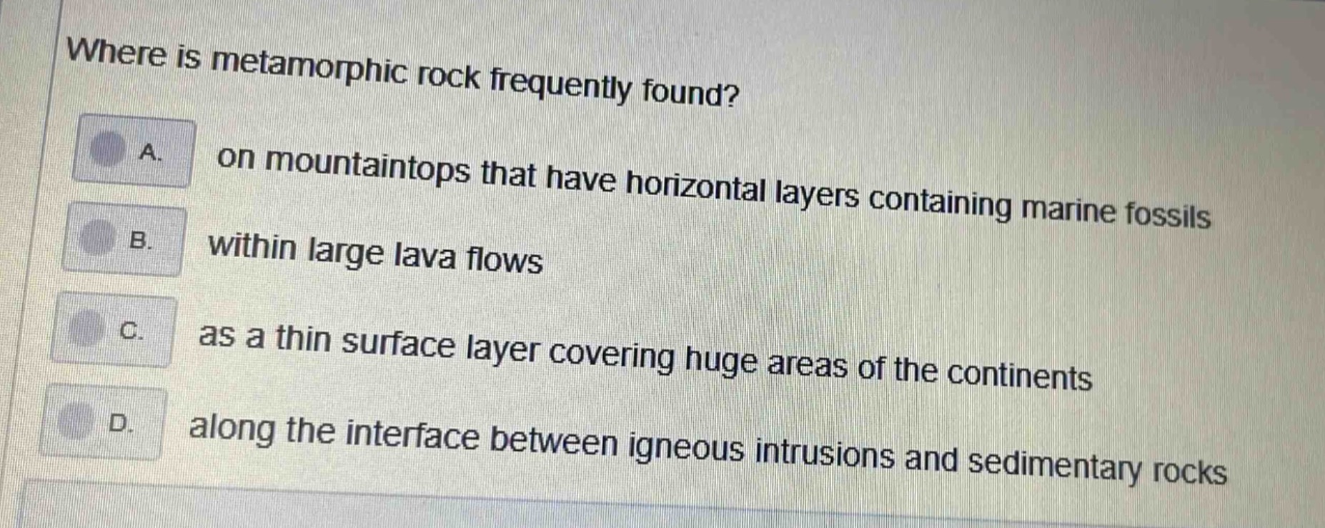 where is metamorphic rock frequently found? a. on mountaintops that have horizontal layers containing marine fossils b. within large lava flows c. as a thin surface layer covering huge areas of the continents d. along the interface between igneous intrusions and sedimentary rocks