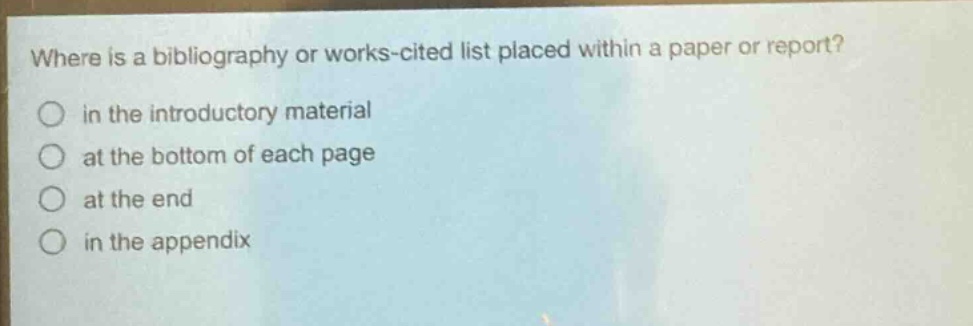 where is a bibliography or works - cited list placed within a paper or report?\n in the introductory material\n at the bottom of each page\n at the end\n in the appendix